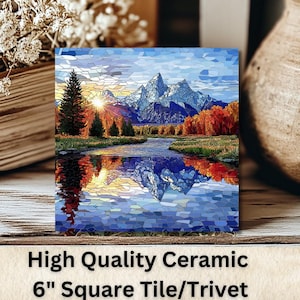 May include: A 6-inch square ceramic tile/trivet featuring a landscape scene with mountains, a river, and colorful trees. The image is reflected in the water. The tile is displayed with a stack of books, dried flowers, and a ceramic vase.