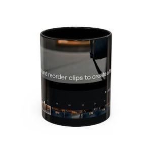 May include: A black ceramic mug featuring a printed graphic of a video editing software interface. The design displays a timeline with thumbnails, a playhead, and the white text "and reorder clips to create a fi" across the center surface.