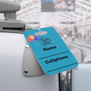 May include: Blue luggage tag with a colorful balloon design and the text "Thank You". The tag has blank spaces for a name and phone number.