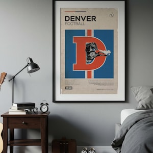 May include: A framed vintage Denver Broncos football poster. The poster features a large orange "D" with a blue background and a graphic of a horse. The text "DENVER FOOTBALL" is at the top, with "1960" at the bottom. The poster is displayed above a nightstand.