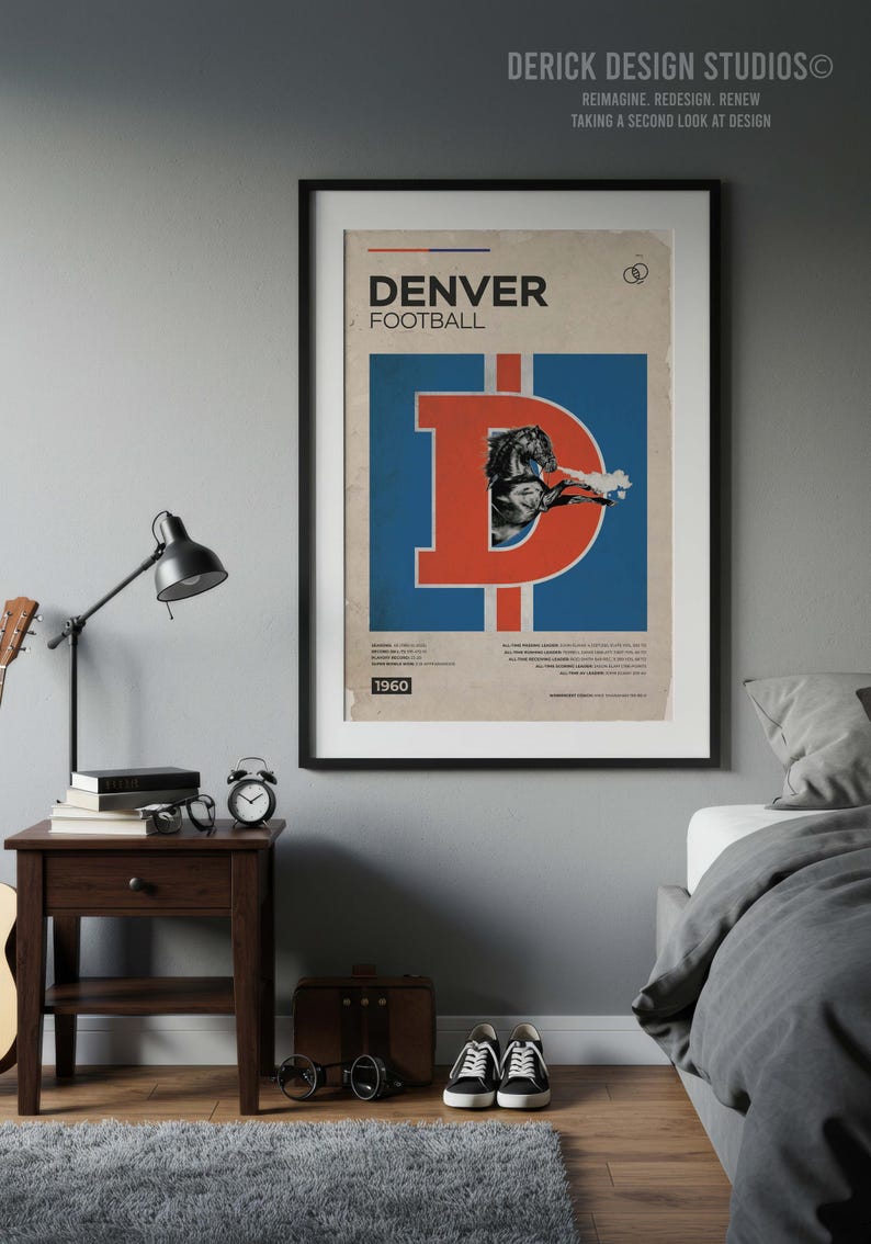 May include: A framed vintage Denver Broncos football poster. The poster features a large orange "D" with a blue background and a graphic of a horse. The text "DENVER FOOTBALL" is at the top, with "1960" at the bottom. The poster is displayed above a nightstand.