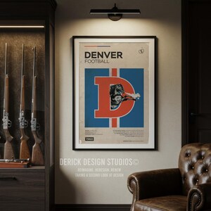 May include: Framed vintage Denver Broncos football poster. The poster features a large orange "D" with a football player image on a blue background. The poster is dated 1960. The room also includes a leather armchair and a cabinet with rifles.
