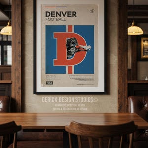 May include: A framed vintage Denver Broncos football poster. The poster features a large orange "D" over a blue background with a football player illustration. The text "DENVER FOOTBALL" is at the top, with "1960" at the bottom. The poster is displayed in a wooden-framed setting.