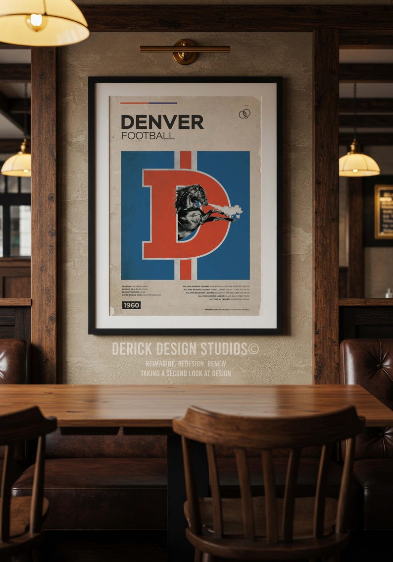 May include: A framed vintage Denver Broncos football poster. The poster features a large orange "D" over a blue background with a football player illustration. The text "DENVER FOOTBALL" is at the top, with "1960" at the bottom. The poster is displayed in a wooden-framed setting.