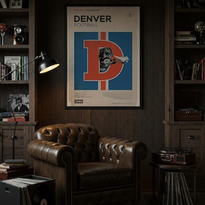 May include: A vintage-style poster with the text "DENVER FOOTBALL" and a large "D" logo in red and blue. The poster is framed and hangs above a brown leather armchair in a room with wooden paneling and bookshelves. The year "1960" is at the bottom.