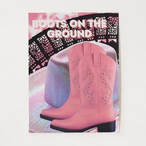May include: Pink cowboy boots with star and stud details are the focal point of this image. The boots are set against a backdrop of a hat and a decorative black fan. The words "BOOTS ON THE GROUND" are displayed at the top.