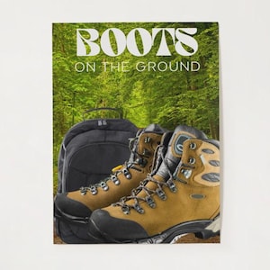 May include: A pair of tan and black hiking boots with a black backpack in front of a forest background. The boots have black soles and laces. The text "BOOTS ON THE GROUND" is at the top of the image.