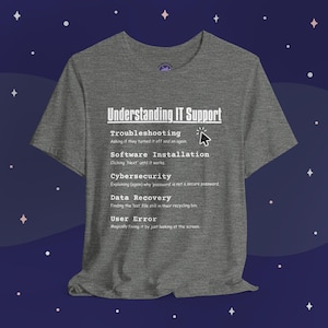 May include: A heather grey t-shirt with a white graphic that defines IT support terms in a humorous way. The graphic includes the text "Understanding IT Support" and lists terms like "Troubleshooting", "Software Installation", "Cybersecurity", "Data Recovery", and "User Error".