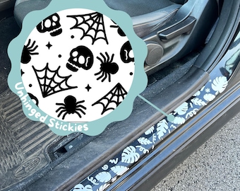 Może przedstawiać: Czarne i białe ochraniacze progów drzwi samochodowych z motywem Halloween. Ochraniacze mają wzór czaszek, pajęczyn, pająków i gwiazd. Tekst "Unhinged Stickies" jest widoczny na zdjęciu.