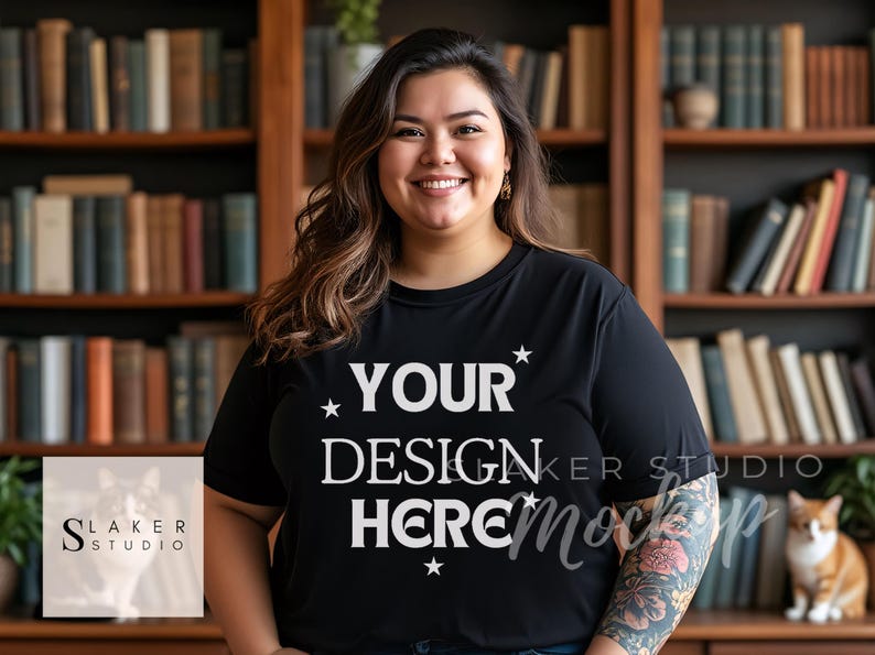 May include: A black t-shirt with the text "YOUR DESIGN HERE" in white lettering and stars. The shirt is being modelled by a person with a tattoo on their arm.