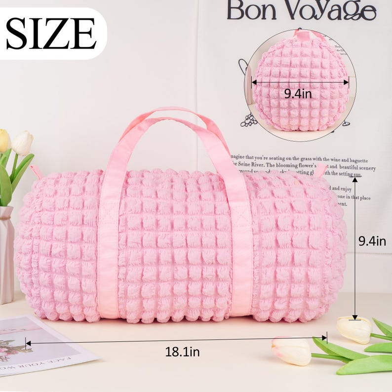 Op de afbeelding: Roze gewatteerde reistas met een bovenste handvat en twee banden. De tas is 46 cm lang en 24 cm hoog.