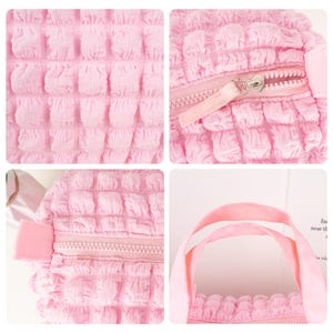Op de afbeelding: Een roze pluche tote bag met rits en een textuur. De tas heeft twee handvatten en een ritssluiting.