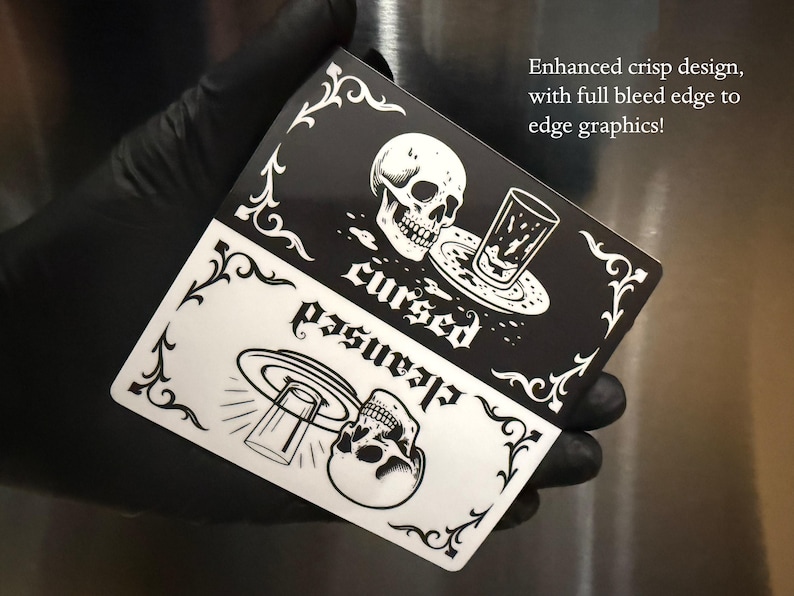 Enhanced crisp design. Full bleed graphic. A black and white slim dishwasher magnet with a gothic theme. The top half features a skull, a glass, and the word 'cursed'. The bottom half shows a skull, a glass, and the word 'cleansed'. Ornate flourishes frame the design.
