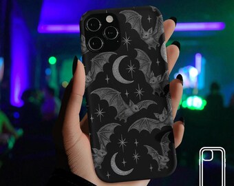 Può includere: Custodia per telefono nera con un motivo ripetuto di pipistrelli, lune crescenti e stelle in scala di grigi. La custodia ha una costruzione a doppio strato. Il tema generale è gotico e celeste.