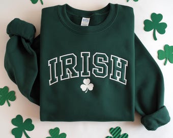 May include: Green sweatshirt with the word "IRISH" in white letters with a black outline. A white shamrock is below the word.