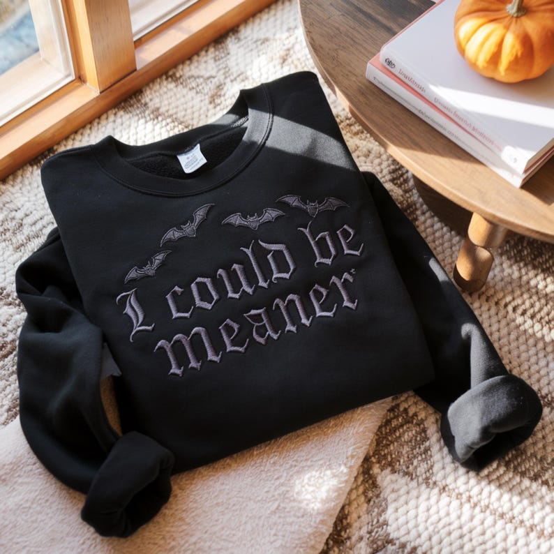 Puede incluir: Sudadera negra con la frase bordada "I could be meaner" y dise&ntilde;os de murci&eacute;lagos. La parte superior de manga larga est&aacute; hecha de un material suave. Una prenda c&oacute;moda para Halloween o el uso diario.