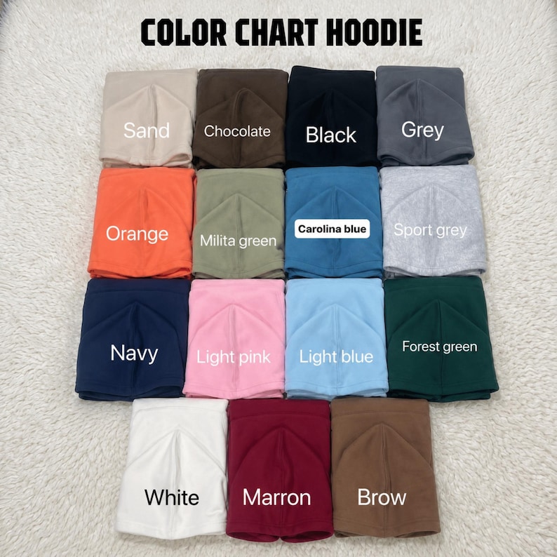 May include: A color chart for hoodies featuring fifteen folded fabric squares in various colors including sand, chocolate, black, grey, orange, military green, Carolina blue, sport grey, navy, light pink, light blue, forest green, white, maroon, and brown.