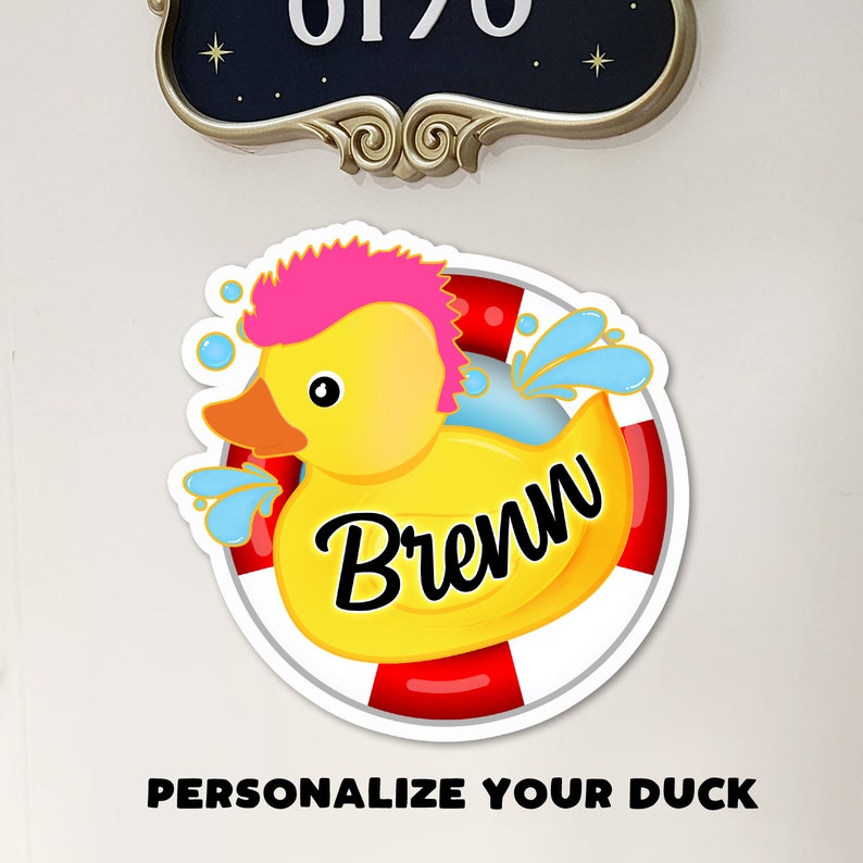 May include: A yellow rubber duck with a pink mohawk, wearing a red and white life preserver. The duck is labeled "Brewn".