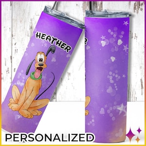 May include: Purple personalized tumbler with a cartoon image of Pluto the dog. The tumbler has a white background with a purple ombre effect and white hearts and stars. The text "HEATHER" is printed on the tumbler.