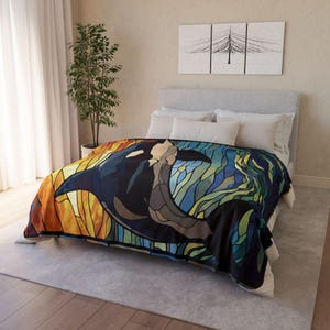 May include: A colorful throw blanket with a stained glass design of an orca swimming in the ocean. The blanket features shades of blue, green, yellow, and orange.
