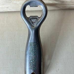 May include: Silver bottle opener with the text "The Upper Canada Brewing Company" on the handle. The opener is made by Ledco in Canada.