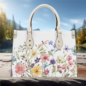 Bolso de mano de lujo de piel sintética para mujer, con asas blancas, diseño de granja cottagecore con hermosas flores silvestres botánicas y libélula primaveral.