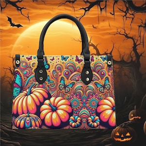 May include: A black leather tote bag with a colorful psychedelic print featuring butterflies and pumpkins. The bag has two top handles and a zipper closure.