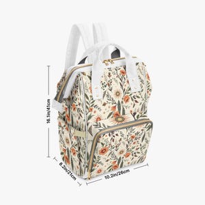 May include: Cream-coloured backpack with a floral pattern featuring orange and green flowers. The bag has white straps and handles, and measures 41cm tall, 26cm wide, and 21cm deep.