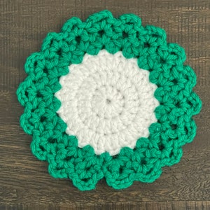 Peut inclure: Un dessous de verre crochet&eacute; vert et blanc avec un bord festonn&eacute;.