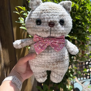 Pu&ograve; includere: Bambola a forma di gatto all'uncinetto fatta a mano con un motivo a righe grigio chiaro e marrone. Il gatto ha occhi a bottone neri, un naso a bottone marrone e un papillon floreale rosa. La bambola &egrave; morbida e soffice.