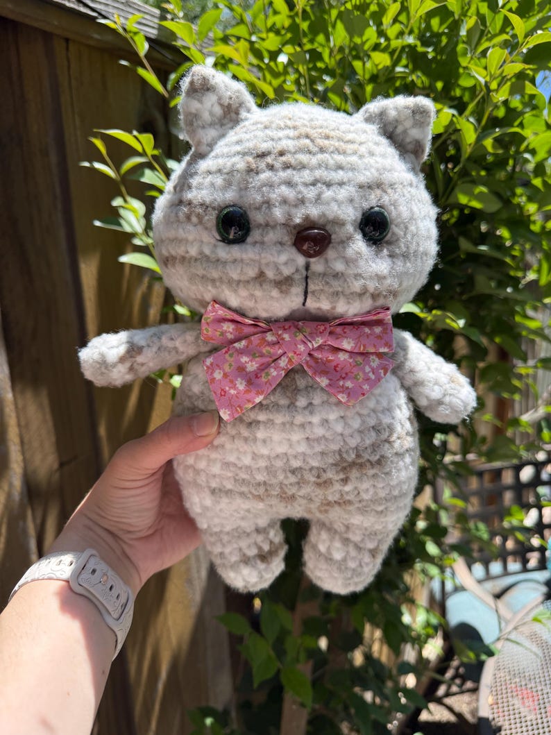 Pu&ograve; includere: Bambola a forma di gatto all'uncinetto fatta a mano con un motivo a righe grigio chiaro e marrone. Il gatto ha occhi a bottone neri, un naso a bottone marrone e un papillon floreale rosa. La bambola &egrave; morbida e soffice.