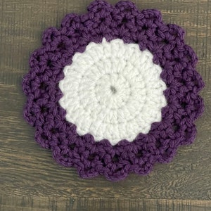 Peut inclure: Un dessous de verre crochet&eacute; avec un centre blanc et une bordure violette. Le dessous de verre a un bord festonn&eacute;.