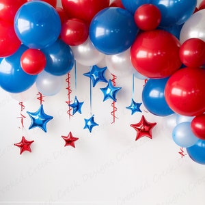 May include: A red, white, and blue balloon garland with red, white, and blue star-shaped decorations hanging from it. The garland is hanging from a white wall.