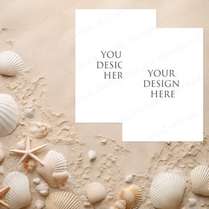 May include: Two blank white cards with the text "Your Design Here" and "You Desic Her" on a beige background with seashells and starfish.