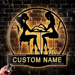 May include: Black metal sign with a silhouette of two figures at a table, illuminated with a warm glow. The sign features the text "CUSTOM NAME" and is set against a brick wall background. A remote control is in the lower left corner.