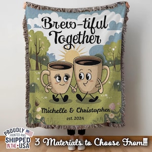 May include: A woven throw blanket with a cartoon illustration of two coffee mugs with faces. The text "Brew-tiful Together" is above the mugs. The text "Michelle & Christopher est. 2024" is below the mugs.