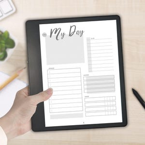 May include: A black digital tablet displaying a white daily planner page titled My Day. The screen layout includes sections for a schedule, to-do list, priorities, and a tracker. The interface features clean black lines and gray shaded boxes.