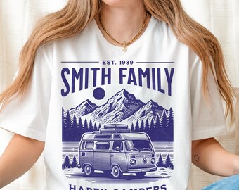 May include: White t-shirt with a blue graphic featuring a vintage camper van, mountains, and the text "SMITH FAMILY HAPPY CAMPERS LAKE TAHOE 2025". The shirt also includes "EST. 1989".