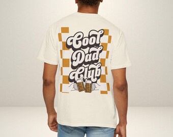 May include: White t-shirt with a checkered pattern in brown and white. The shirt has a graphic print of the text "Cool Dad Club" in a retro font with two beer mugs.