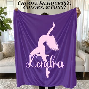 May include: A purple blanket featuring a light pink silhouette of a dancer with the name "Kendra" in a cursive font. The blanket has the text "CHOOSE SILHOUETTE, COLORS, & FONT!" at the top.