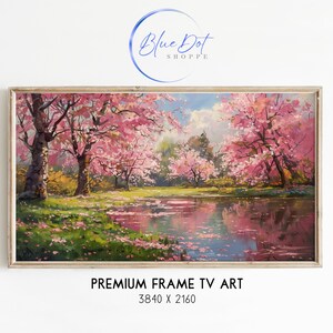 Puede incluir: Una pintura enmarcada de un lago rodeado de árboles de cerezo en flor rosa. El lago refleja los árboles y el cielo. La pintura está en un marco de madera. PREMIUM FRAME TV ART 3840 x 2160