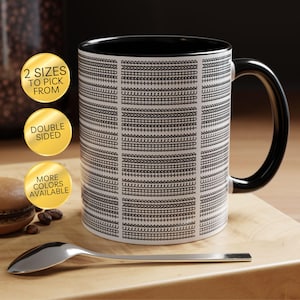 May include: A white ceramic mug with a black interior and handle, featuring a repeating black geometric pattern of horizontal lines and small shapes. Three gold circular badges display the text 2 SIZES TO PICK FROM, DOUBLE SIDED, and MORE COLORS AVAILABLE.