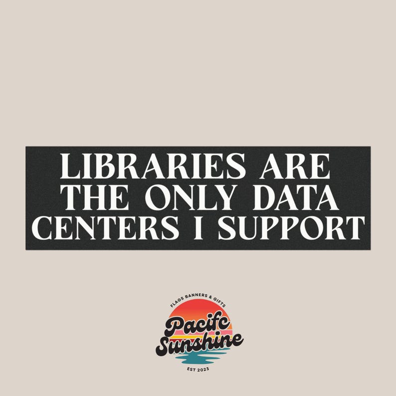 Puede incluir: Un letrero rectangular negro con el texto blanco LIBRARIES ARE THE ONLY DATA CENTERS I SUPPORT en una fuente serif. Debajo del texto hay un logotipo circular con un gr&aacute;fico de atardecer y las palabras Pacific Sunshine Flags Banners & Gifts Est 2023.