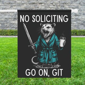 Pode incluir: Bandeira de jardim preta com o texto "NO SOLICITING" acima de uma ilustra&ccedil;&atilde;o de um gamb&aacute; em um roup&atilde;o azul-petr&oacute;leo segurando uma espada e uma x&iacute;cara de caf&eacute;. O texto "GO ON, GIT" est&aacute; abaixo do gamb&aacute;.