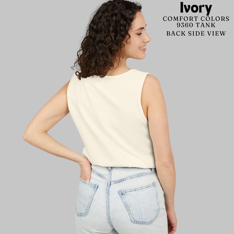 May include: An ivory Comfort Colors 9360 tank top shown from the back, paired with light-wash blue denim jeans. The text in the upper right corner reads: Ivory, Comfort Colors, 9360 Tank, Back Side View. The tank features a sleeveless design.