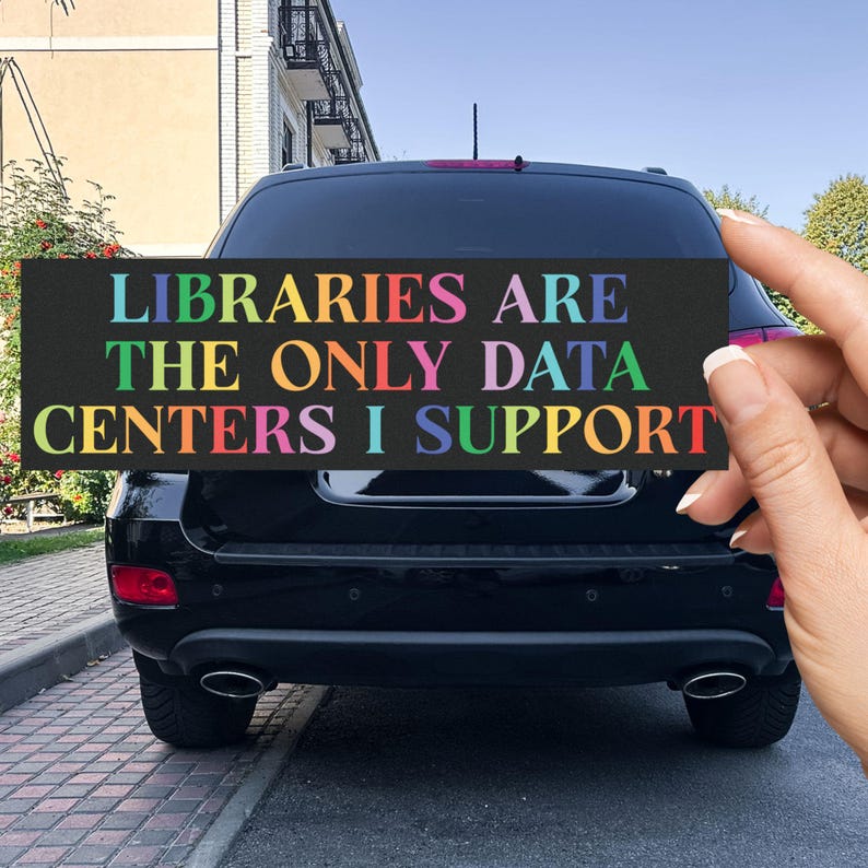 Puede incluir: Una pegatina rectangular para parachoques con fondo negro y texto multicolor que dice LIBRARIES ARE THE ONLY DATA CENTERS I SUPPORT. Las letras est&aacute;n impresas en varios colores, incluyendo azul, amarillo, rosa, verde y naranja.