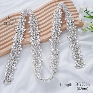 Könnte beinhalten: Ein silberner Perlenbesatz mit klaren Strasssteinen. Der Besatz ist 1 3/8 Zoll breit und 36 1/4 Zoll lang.