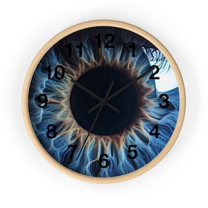May include: A round wall clock with a blue eye design. The clock face features black numbers 1 through 12 and black hour and minute hands.
