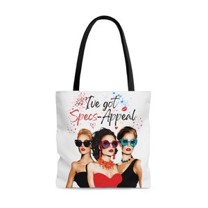 May include: White tote bag with a colorful graphic of three women wearing sunglasses and the text "I've got Specs-Appeal".