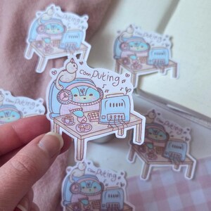 May include: A collection of stickers featuring a cartoon character with headphones, working on a computer at a small desk. The stickers have a pastel color scheme with the text "com puting".